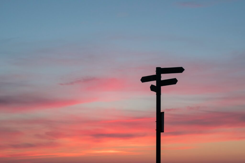 a street sign with a sunset in the background